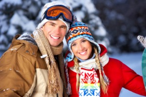 Skiing couple smile happily, showing off the dental veneers they got in Jefferson City from Dr. Justin Johnson.