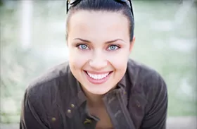 Happy girl shows off her beautiful porcelain dental veneers for teeth in Jefferson City.