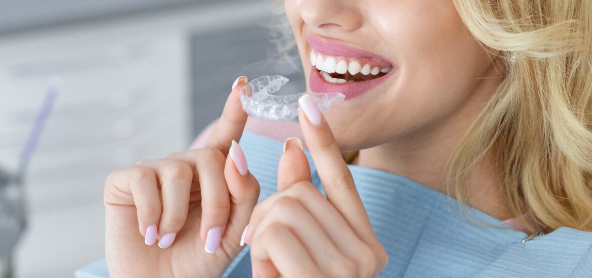 adult woman placing her clear aligners in mouth