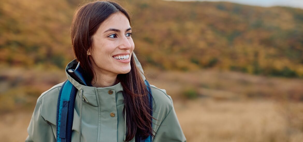 Happy woman enjoying outdoor adventure, looking away with a natural smile